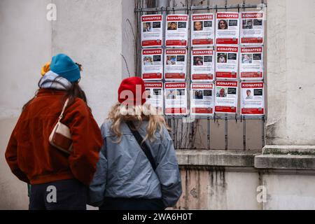 January 1, 2024, KrakÃ³w, Poland: People look at images of Israeli hostages kidnapped by Hamas hanging on a gate of Jewish Community Centre in Krakow, Poland on January 1st, 2024. Around 240 people were taken captive by Hamas during the terror attack on Israel on October 7th 2023, with 105 prisoners later being released during a six-day ceasefire at the end of November. (Credit Image: © Beata Zawrzel/ZUMA Press Wire) EDITORIAL USAGE ONLY! Not for Commercial USAGE! Stock Photo