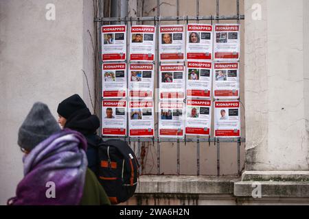 January 1, 2024, KrakÃ³w, Poland: People walk past Images of Israeli hostages kidnapped by Hamas hanging on a gate of Jewish Community Centre in Krakow, Poland on January 1st, 2024. Around 240 people were taken captive by Hamas during the terror attack on Israel on October 7th 2023, with 105 prisoners later being released during a six-day ceasefire at the end of November. (Credit Image: © Beata Zawrzel/ZUMA Press Wire) EDITORIAL USAGE ONLY! Not for Commercial USAGE! Stock Photo