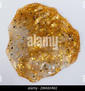 Gold color piece of shiny slice isolated on white studio background Stock Photo