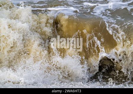 Wave crashing /rolling on beach during winter storm along North Sea coast in Zeeland, Netherlands Stock Photo