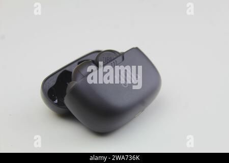 Dublin, Ireland - January 3rd 2024: A close up photo of a JBL black earbuds and earphone case on a white surface. Stock Photo