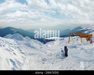 Snow-covered ski hoist ropeway (upper  terminal) and mountain landscape behind (Ukraine, Carpathian Mt's, Drahobrat ski resort). Stock Photo