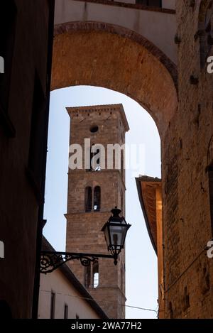 Old Romanesque bell tower of a church in downtown Volterra, Italy Stock Photo