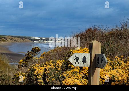 A coastal path sign indicates the way above Hunmanby Sands, a vast area of sands between Bridlington in the south and Filey to the north. Stock Photo