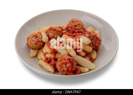 Gnocchi with tomato sauce and meatballs in white plate isolated on white with clipping path included. Typical gnocchi from the Italian Alps. Gnocchi f Stock Photo