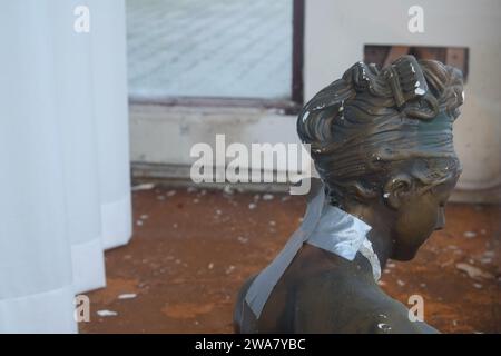 Busted female bust fixed with duct tape in a dirty shabby deserted shop window Stock Photo