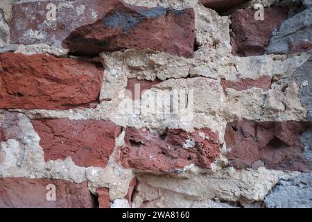 close up of an urban textured, damaged and grunge old brick stones with mortar & cement  Beautiful wallpaper, background, structural patterns Stock Photo