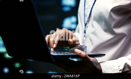 Extreme close up shot of experienced IT programmer using laptop to audit high tech facility security to protect information access, making sure virus protection software is updated Stock Photo