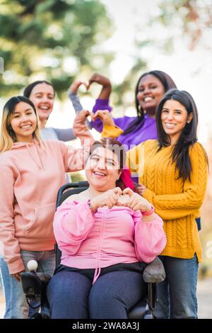 Inspire Inclusion international womens day. Diverse group do heart love with hands. Disability  Stock Photo