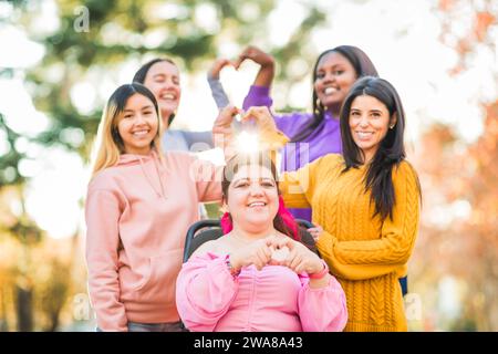 Inspire Inclusion international womens day. Diverse group do heart love with hands. Disability  Stock Photo