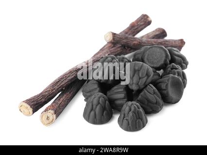 Many tasty candies and dried sticks of liquorice root isolated on white Stock Photo