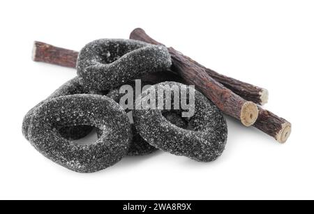 Many tasty candies and dried sticks of liquorice root isolated on white Stock Photo