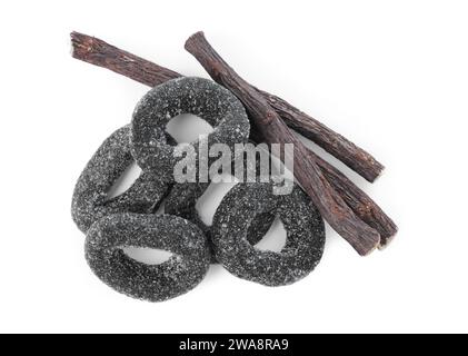 Many tasty candies and dried sticks of liquorice root isolated on white, top view Stock Photo