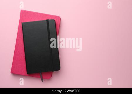 Different notebooks on light pink background, top view. Space for text Stock Photo