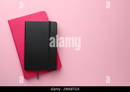 Different notebooks on light pink background, top view. Space for text Stock Photo