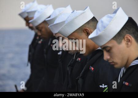 US military forces. 171130RL456-0007 ATLANTIC OCEAN (Nov. 30, 2017) Sailors part of the rifle detail bow their heads in prayer during a Burial at Sea ceremony held on the starboard aircraft elevator of the amphibious assault ship USS Iwo Jima (LHD 7). Iwo Jima, components of the Iwo Jima Amphibious Ready Group and the 26th Marine Expeditionary Unit are conducting a combined composite training unit exercise that is the culmination of training for the Navy-Marine Corps team and will certify them for deployment. (U.S. Navy photo by Mass Communication 2nd Class Hunter S. Harwell/Released) Stock Photo