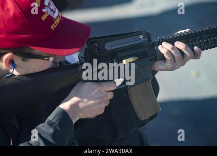 US military forces. BAY OF CADIZ (Jan. 19, 2018) Ensign Nicolas McGrath shoots an M4 rifle during a small-arms gun shoot on the flight deck of the Arleigh Burke-class guided-missile destroyer USS Ross (DDG 71) Jan. 19, 2018. Ross, forward-deployed to Rota, Spain, is on its sixth patrol in the U.S. 6th Fleet area of operations in support of regional allies and partners and U.S. national security interests in Europe. (U.S. Navy photo by Mass Communication Specialist 1st Class Kyle Steckler/Released) Stock Photo