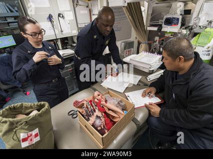 US military forces. 180205RG482-173 ADRIATIC SEA (Feb. 5, 2018) Senior Chief Hospital Corpsman Atiba Mathlin, middle, from the Afloat Training Group, and Hospital Corpsman 1st Class Jasonlee Ordonez, right, prepare a medical emergency drill with Boatswain's Mate 3rd Class Tonya Riker, left, acting as one of the simulated casualties aboard the Arleigh Burke-class guided-missile destroyer USS Ross (DDG 71) Feb. 5, 2018. Ross, forward-deployed to Rota, Spain, is on its sixth patrol in the U.S. 6th Fleet area of operations in support of regional allies and partners and U.S. national security inter Stock Photo