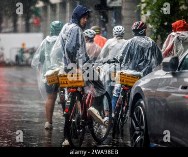 Tourists on a Berlin On Bike cycling tour protect themselves from heavy rainfall with rain capes, Berlin, 23 06 2023 Stock Photo