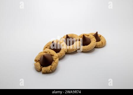 Close up view of a small group of homemade peanut butter cookies with a chocolate drop on top, on a white background with copy space Stock Photo