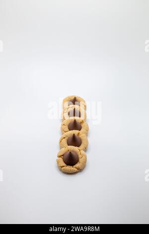 Close up view of a small group of homemade peanut butter cookies with a chocolate drop on top, on a white background with copy space Stock Photo