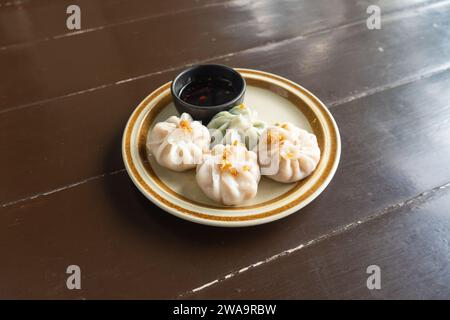 Image of plates containing steamed and chives dumplings, white flour water dough, pork and mixed vegetable filling. Steamed chives dumplings top view Stock Photo