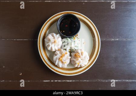 Image of plates containing steamed and chives dumplings, white flour water dough, pork and mixed vegetable filling. Steamed chives dumplings top view Stock Photo