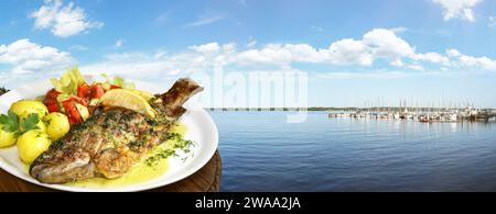 Fishing Lake with grilled Trout on a Plate - Panorama Stock Photo