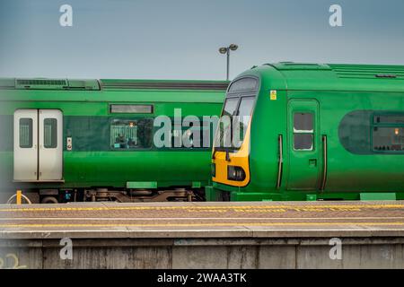 Side view of trains on Drogheda macbride train station in ireland, on a line from Dublin to Belfast. Rail platforms and trains passing by on a sunny d Stock Photo