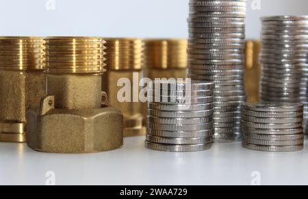 Male Brass Water Meter Fittings And Union Nuts With Columns Of Variety Coins In A Columns Closeup View Stock Photo