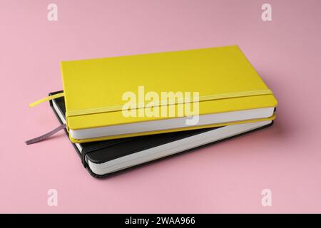 Yellow and black notebooks on light pink background Stock Photo