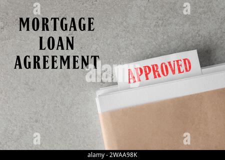 Mortgage loan agreement. Note with Approved stamp in documentation on light grey table, top view Stock Photo