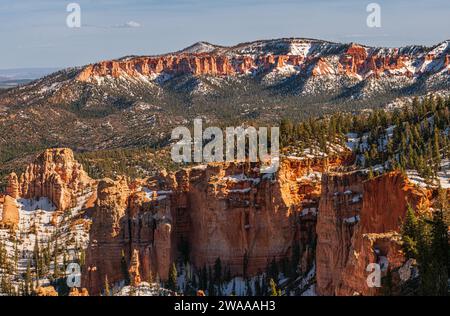 Panorama over Bryce Canyon from a high viewpoint, snow remaining on the ground, clear blue sky, forest, hoodoos. Stock Photo
