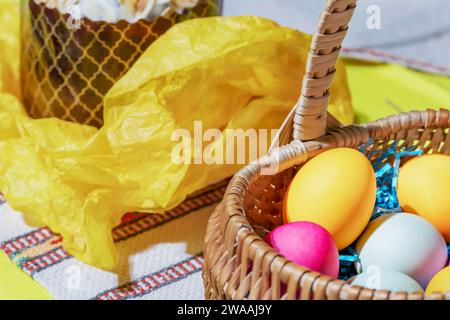 Traditional festive holiday Easter table with basket of colorful eggs and a Easter cake on embroidery napkin. Orthodox Easter. Close up Stock Photo