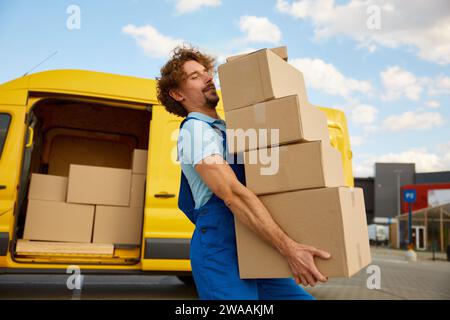 Deliveryman carrying pile of cardboard boxes Stock Photo