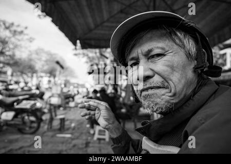 A man from Vietnam is smoking a cigarette Stock Photo