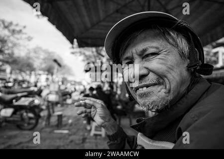 A man from Vietnam is smoking a cigarette Stock Photo