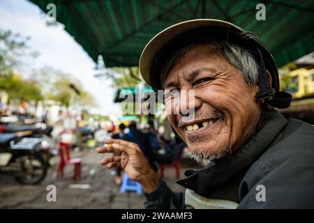 A man from Vietnam is smoking a cigarette Stock Photo