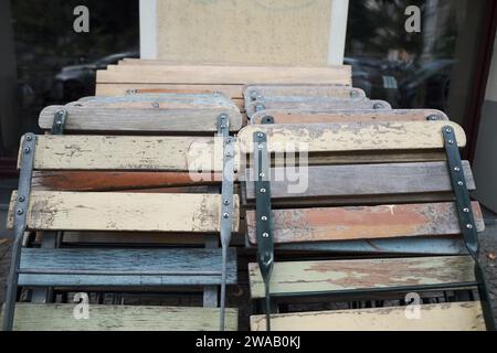 packed wooden folding chairs in old decaying paint colours Stock Photo