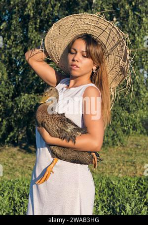 Girl in a hat with a goose Stock Photo