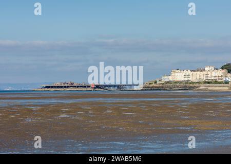 The derelict Birnbeck Pier and Birnbeck Island in the Bristol Channel from the beach at the seaside town of Weston-super-Mare, North Somerset, England. Stock Photo