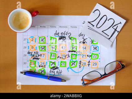 Calendar with business appointments for the new year 2024,pen,coffee cup and spectacles, monthly schedule with days off for better life work balance.B Stock Photo