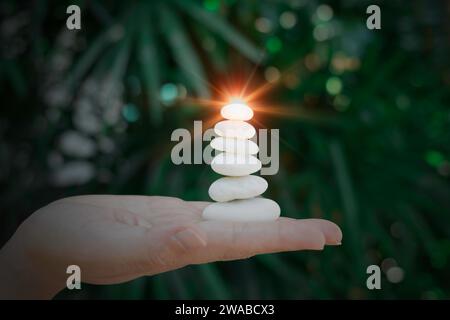 Build pebble stack on the sea shore on hand copy space and natural pebble stone beautiful. Concentration, balanced body, spirit, soul and relaxation c Stock Photo