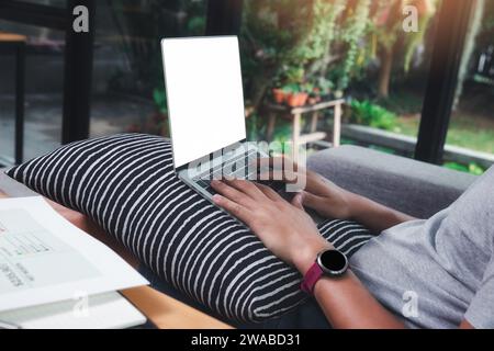 A man in casual wear using laptop while he is  remotely working at home office. Stock Photo
