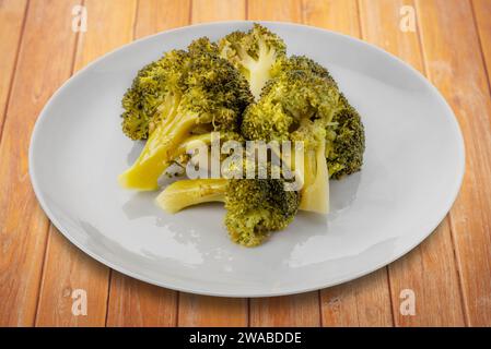 Boiled broccoli in dish on wooden table, clipping path included Stock Photo