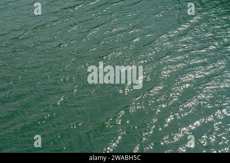 River from above, ocean water surface aerial view, water texture background, light blue green reflection on lake wave ripples flat surface. Sun light Stock Photo
