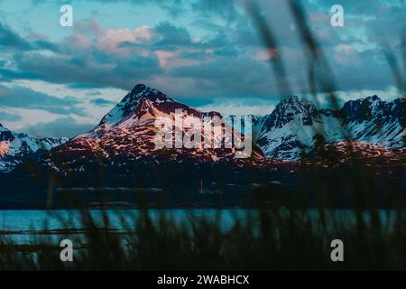 Sunset bursting with colors over lakeside mountains in Alaska. Stock Photo