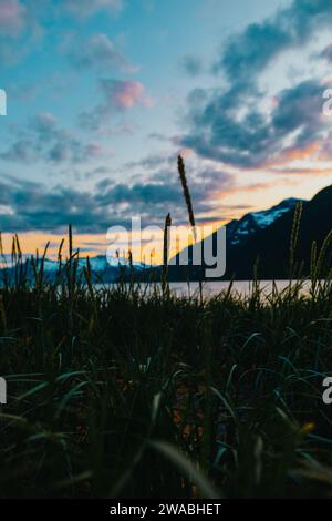 Sunset bursting with colors over lakeside mountains in Alaska. Stock Photo