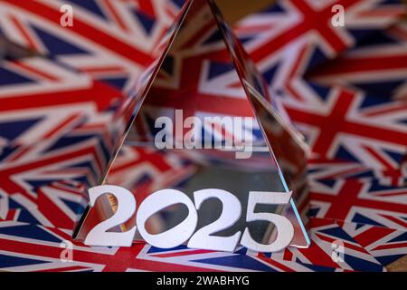 The numbers 2025 lent against  crystal pyramid on top of Union Jack Paper Stock Photo