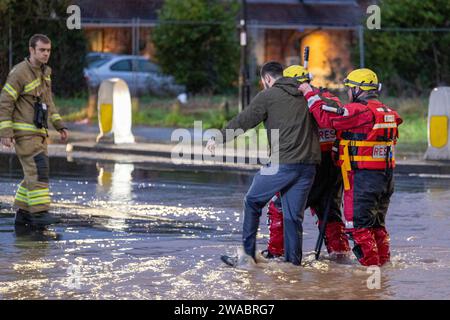 At the start of 2024 Storm Henk saw large parts of the Midlands under water after severe flooding. Pictured, firefighters rescue a motorist and guide him to safety duriing the flood. The rescue taking place on the Tamworth Road B5000 in the village of Polesworth, North Warwickshire where vehicles had become trapped in the deep water. Stock Photo